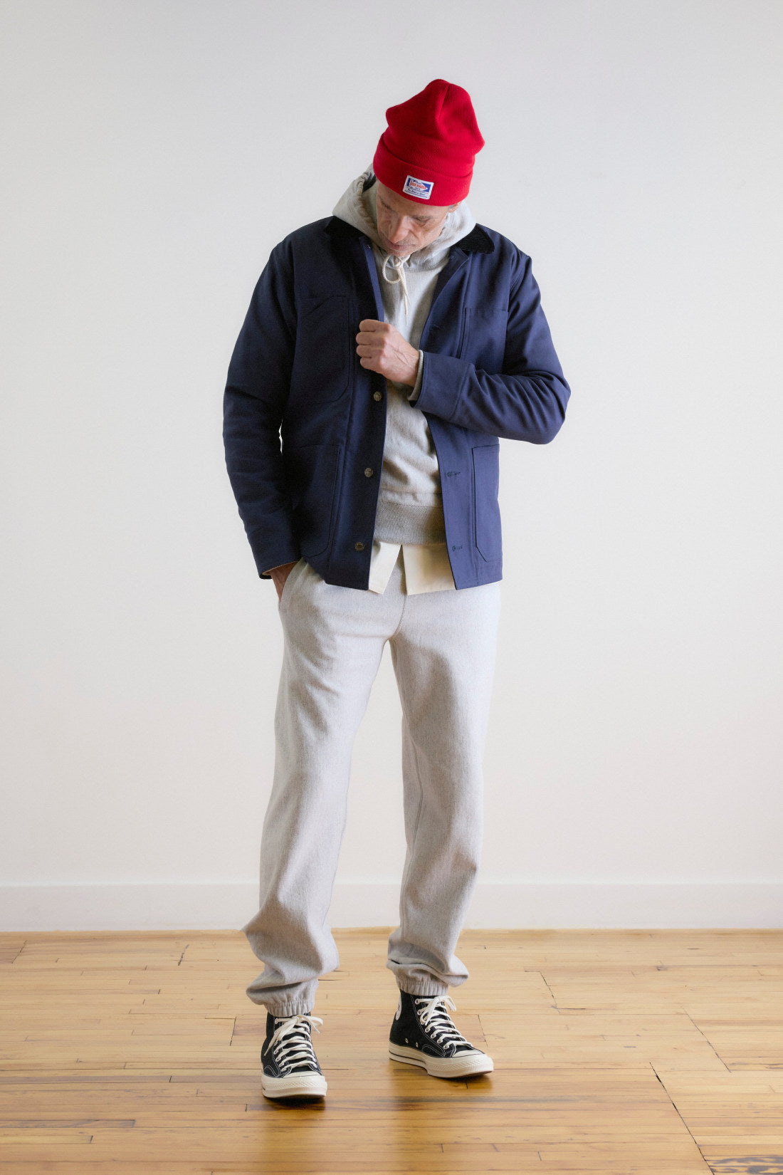 The navy Dufferin Lined Chore Coat worn open over a hooded sweatshirt, cut and sewn in Parkdale, Toronto