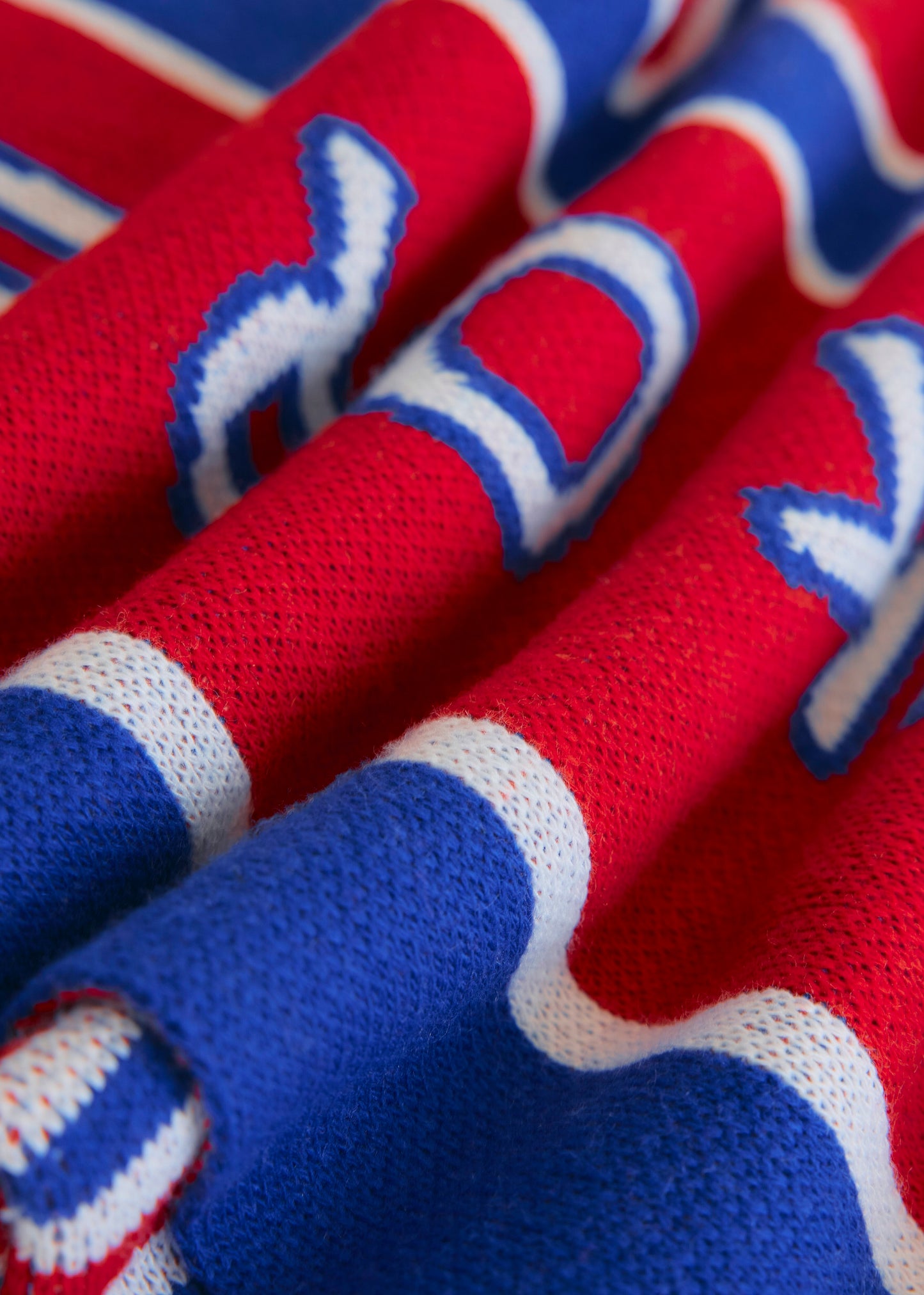 Close up of red and blue knitted blanket showing texture. 